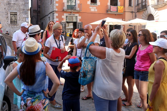 Tourists in the old town of Girona on a guided tour.