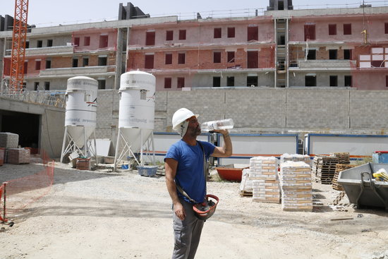 A construction worker takes a break to drink some water