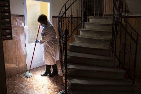A domestic worker cleans a staircase