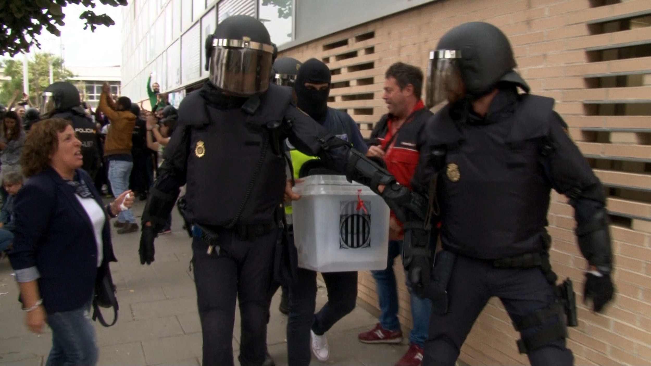 Spanish police officers take away a ballot box at a polling station in Lleida on October 1, 2017.