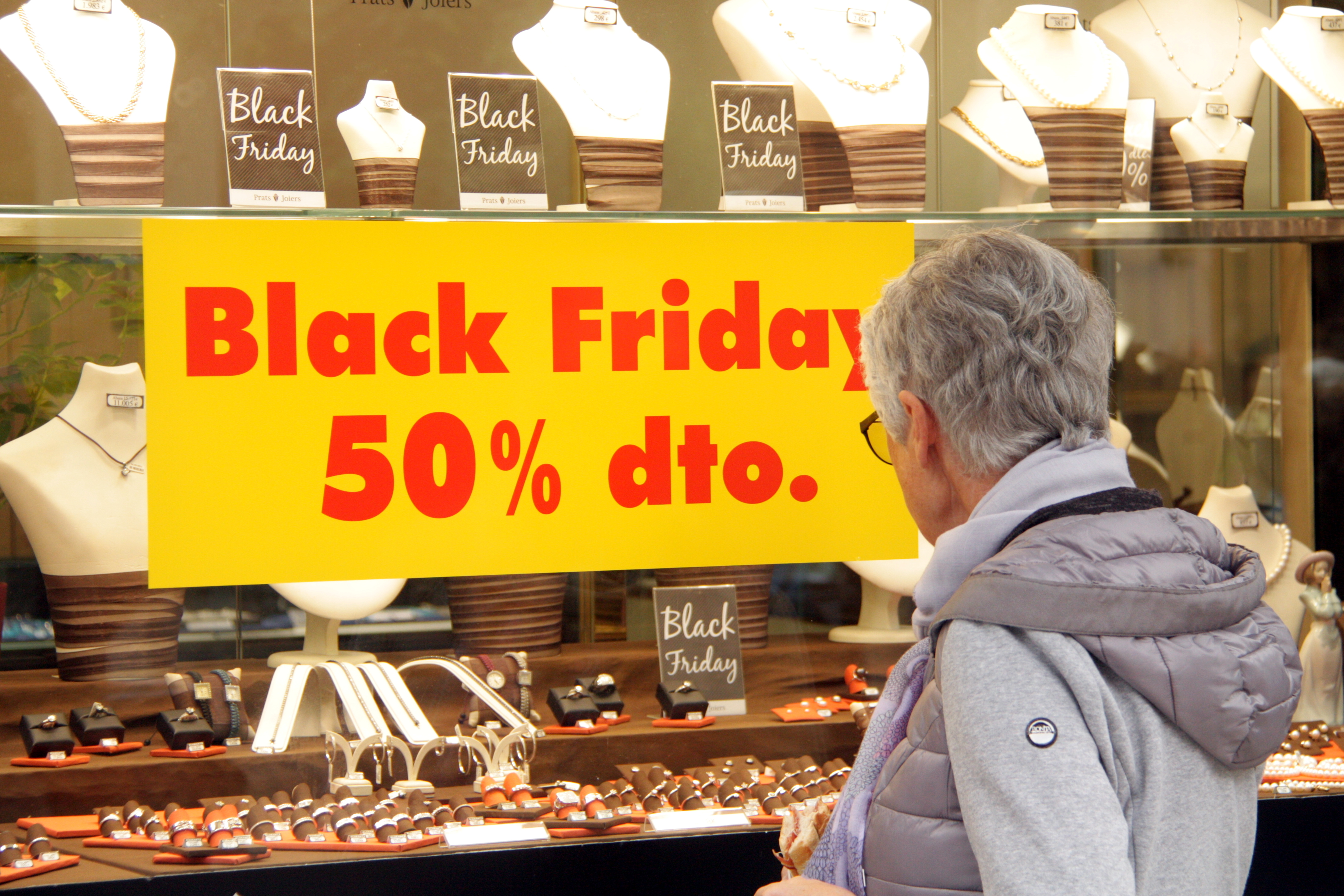 Persona mirant un aparador amb un cartell de 'Black Friday' i un 50% de descompte, el 23 de novembre de 2018. (Horitzontal)