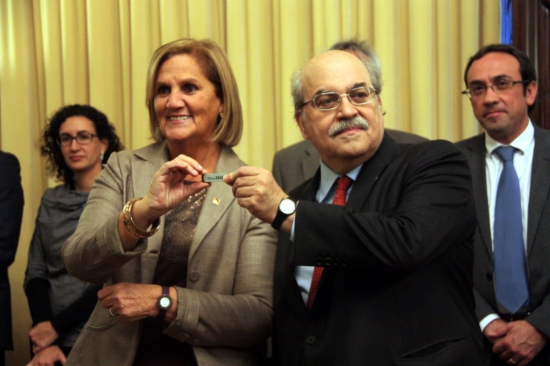 The Catalan Parliament's President, Núria de Gispert (left) receives the USB stick with the Catalan Government's budget from Andreu Mas-Colell (right) (by P. Mateu)