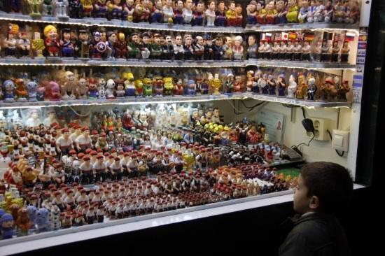 A kid looking at many Caganer figurines to sell (by ACN)