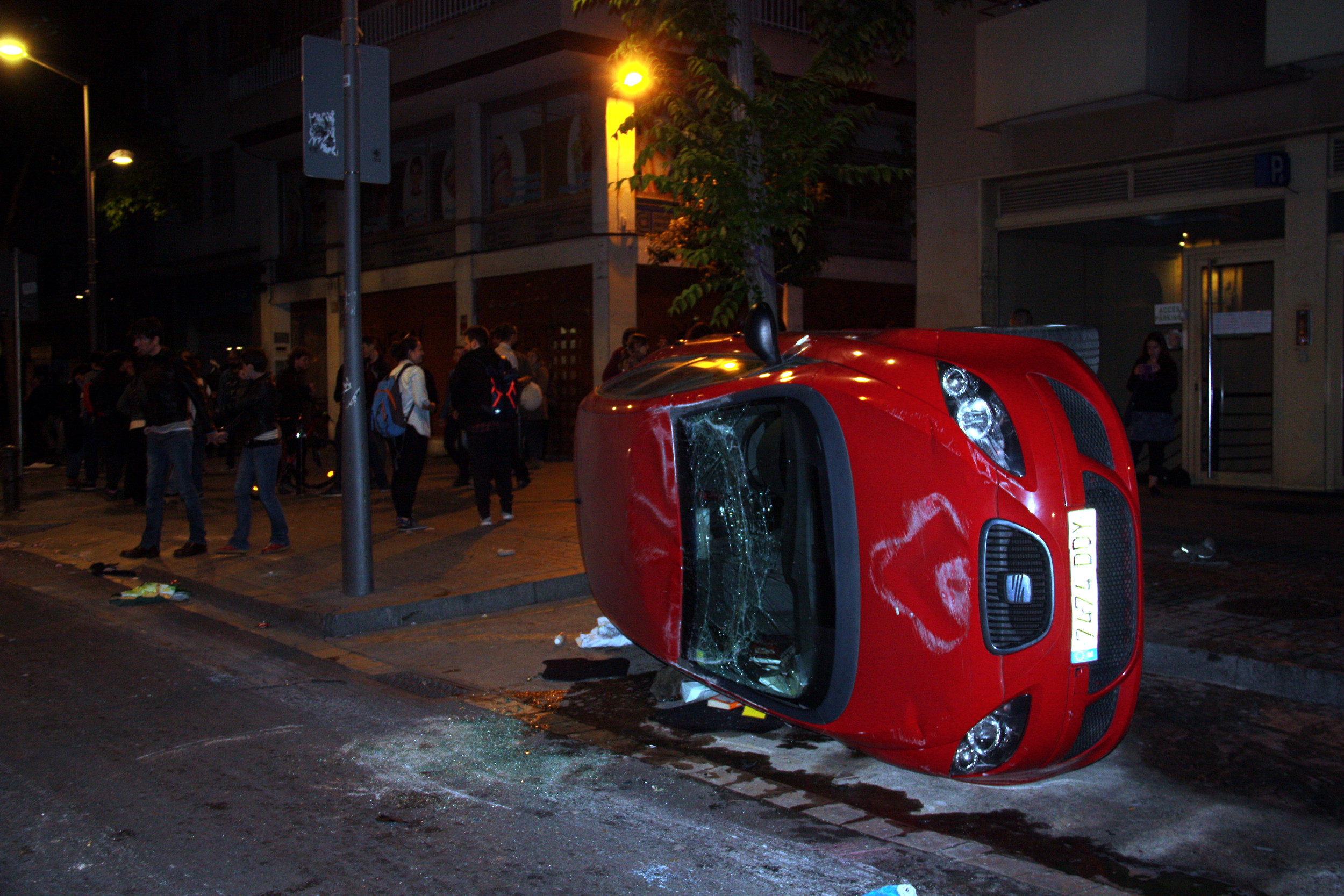 Image of an overturned car due to the riots occurred this Monday night in Gracia (by ACN)