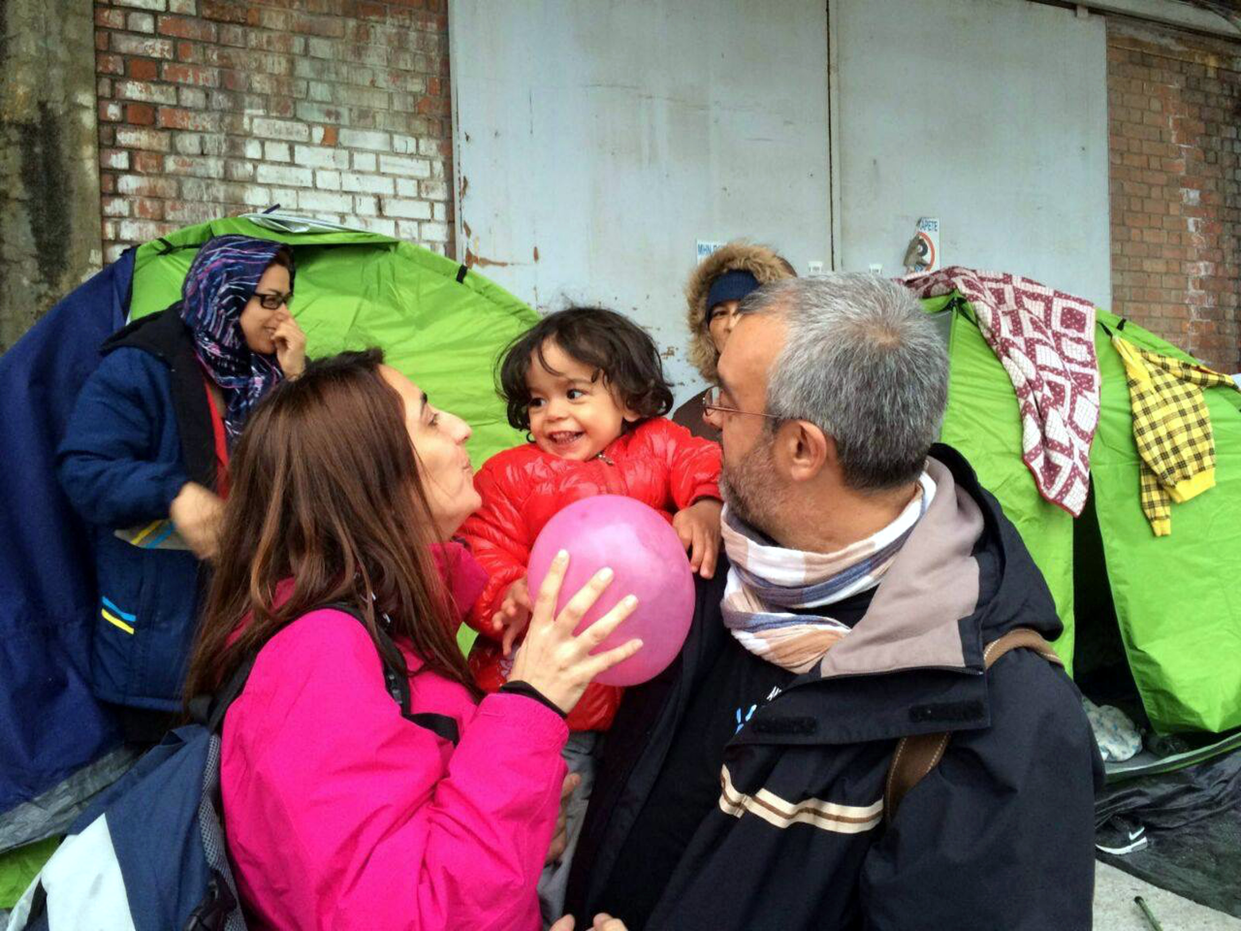 A woman and a man with a little girl in a refugee camp (by ACN)