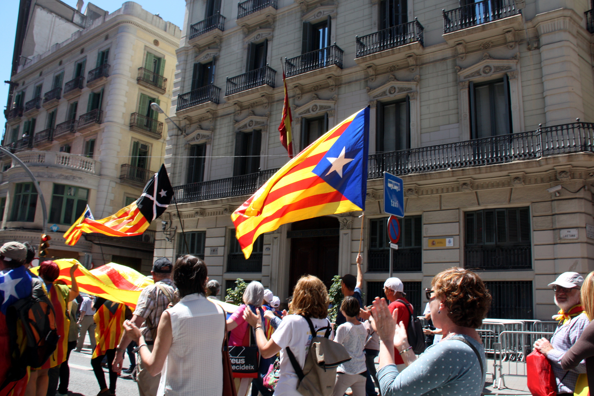Pro-independence supporters demonstrating in front of a police station displaying the Spanish flag (by ACN)