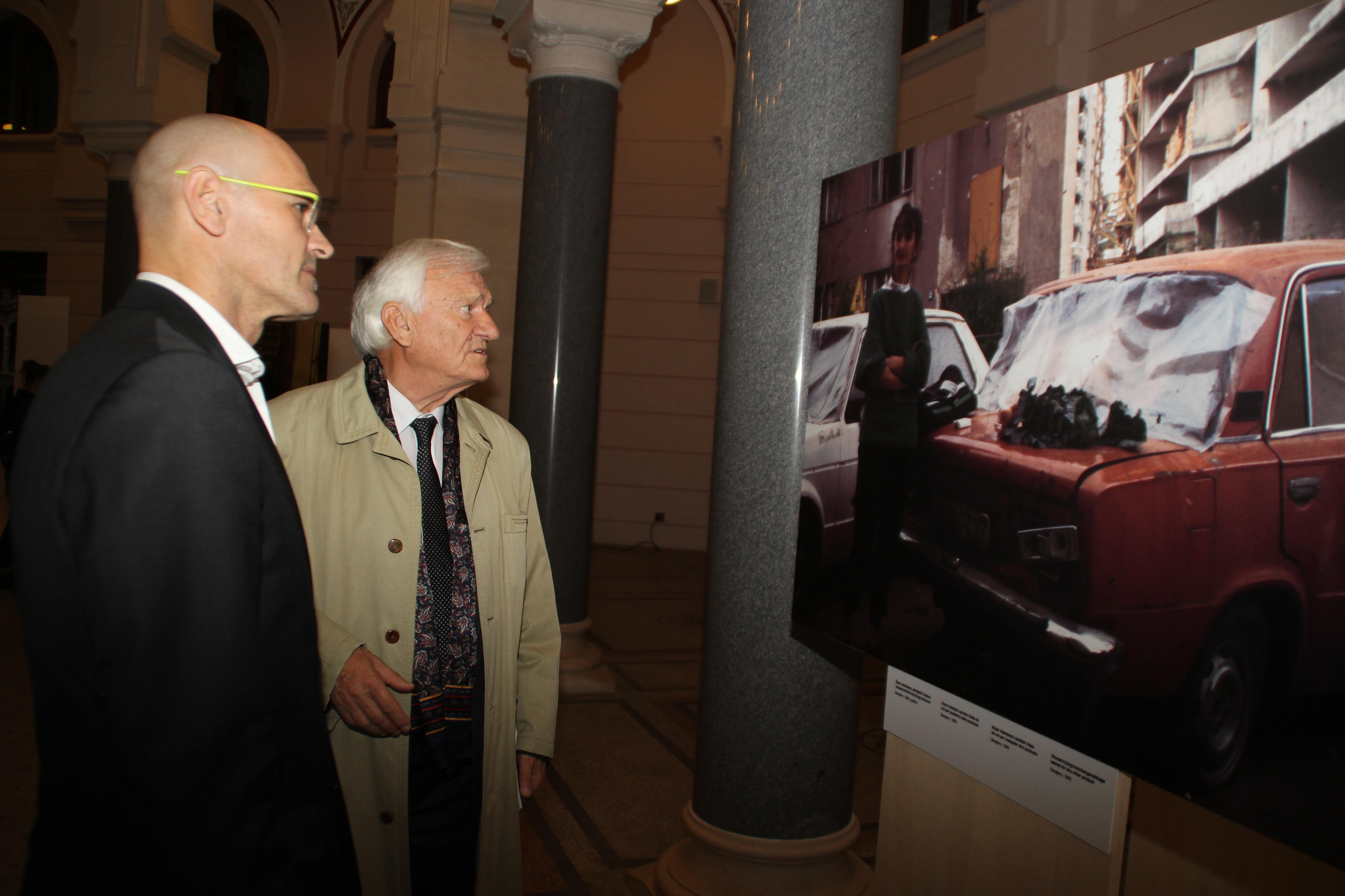 The Catalan Minister of Foreign Affairs, Raül Romeva, looking at a photo of the exhibition in Sarajevo with the former General Jovan Divjak (by ACN)
