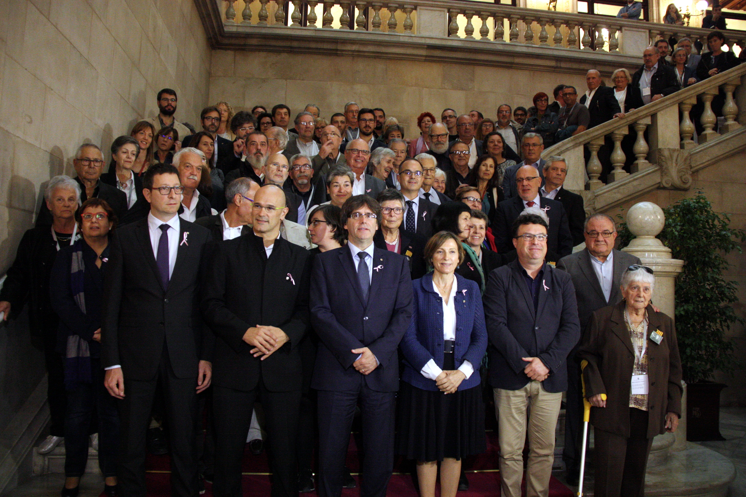 Family picture of the victims of Francoism with the Catalan President, Carles Puigdemont; the President of the Catalan Parliament, Carme Forcadell, and the Catalan Ministers Mundó and Romeva (by ANC). 