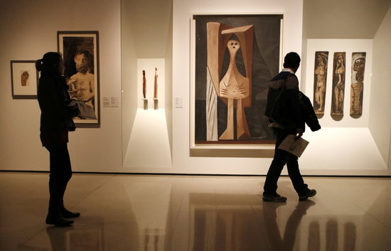 Two people observe Picasso's works in one of the halls of Romanesque Art of the MNAC (by ACN)
