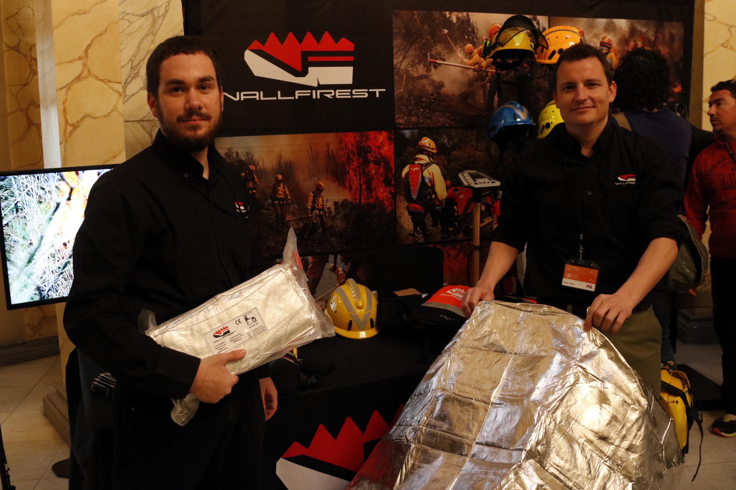 'Vallfirest' chairman, Javier Baena, and one of his collaborator showing the new survival kit for firefighters (by ACN)