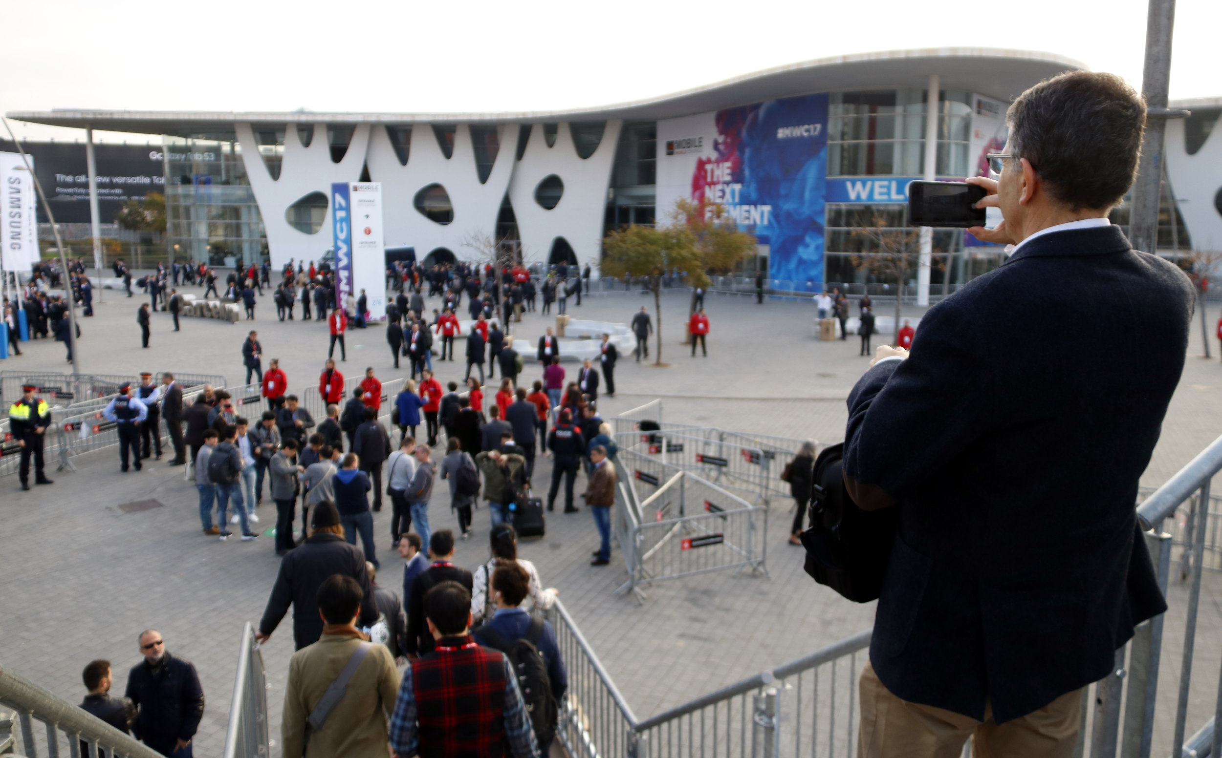 A man takes a picture of the Mobile World Congress' main entrance, at L'Hospitalet Gran Via (by ACN)