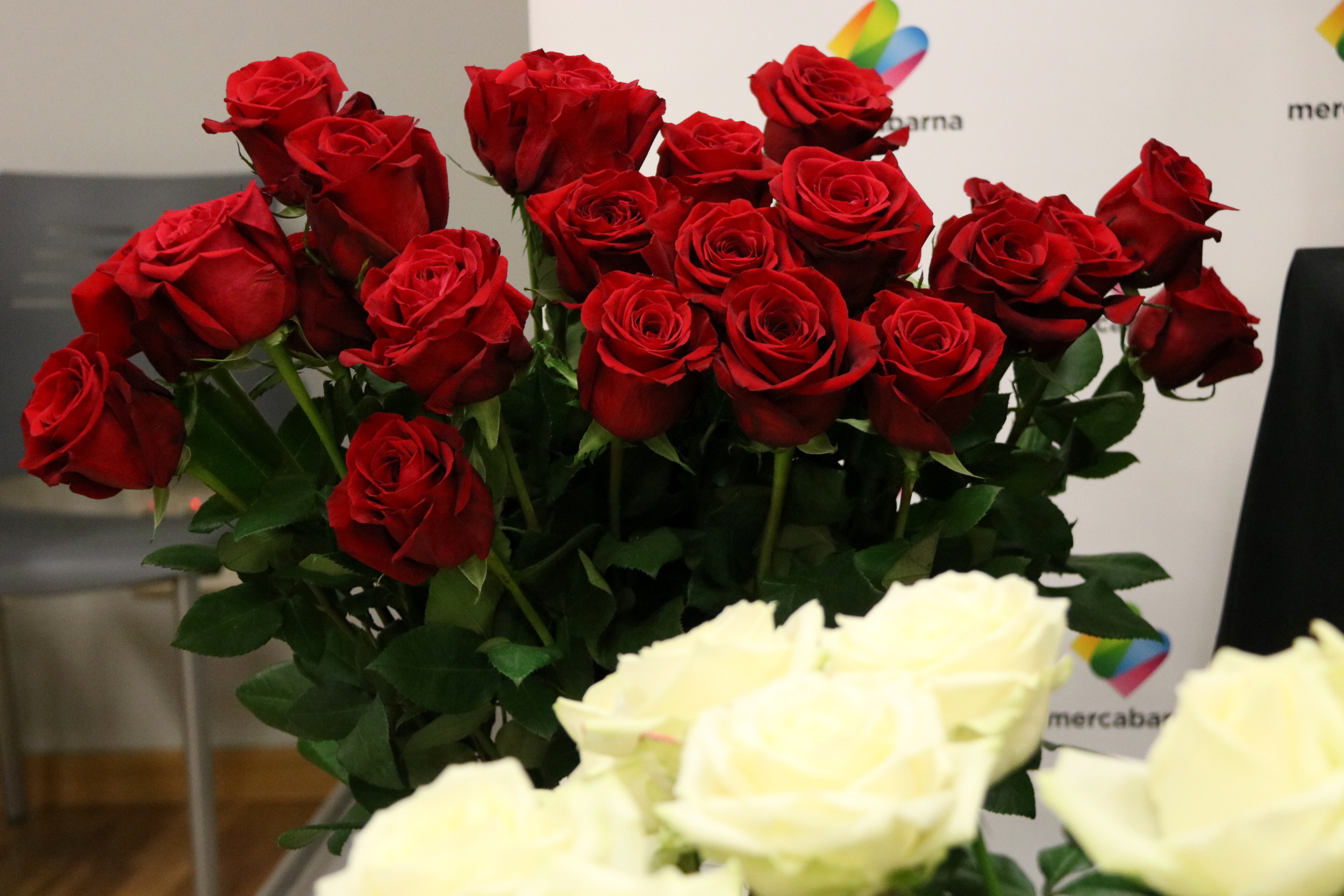 A bouquet of 'Freedom' red roses and white flowers on the foreground (by ACN)