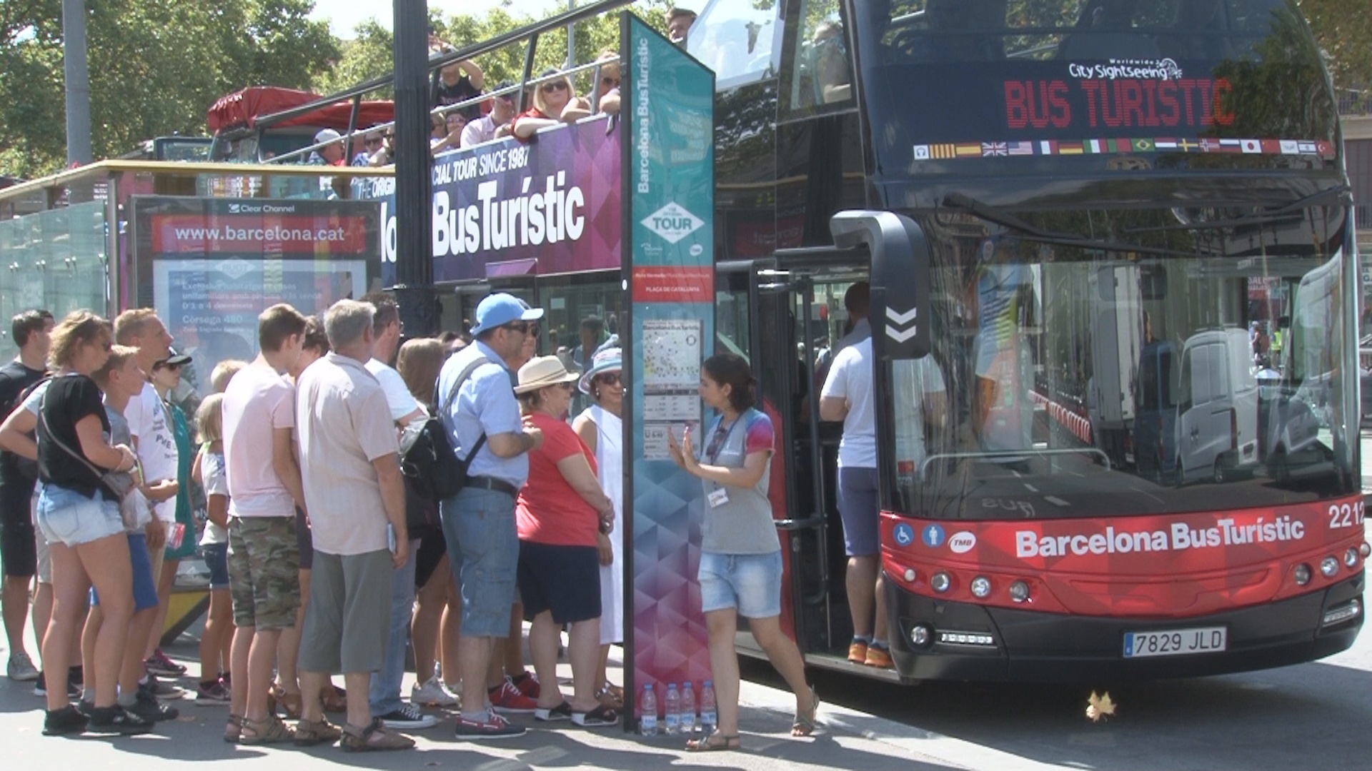 Tourists waiting in line at the tour bus stop