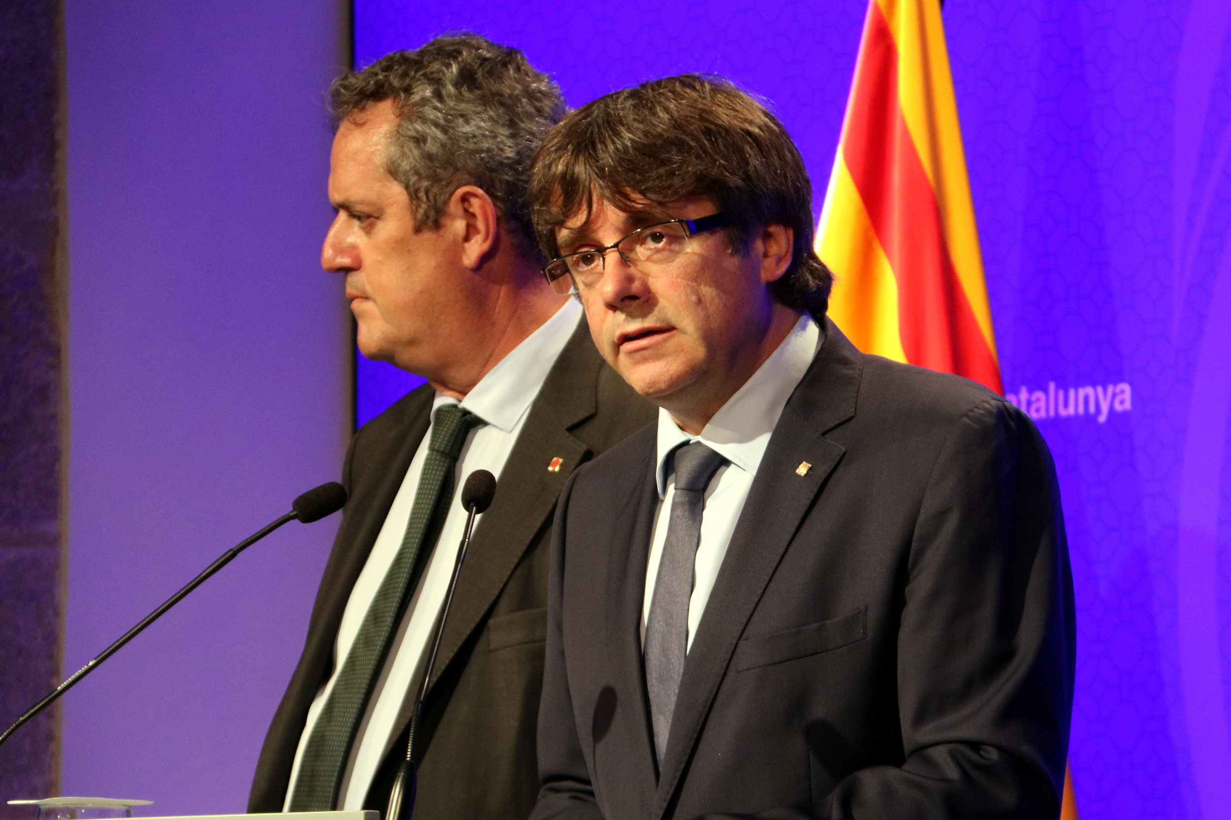 The Catalan president, Carles Puigdemont, speaking next to the home affairs minister, Joaquim Forn