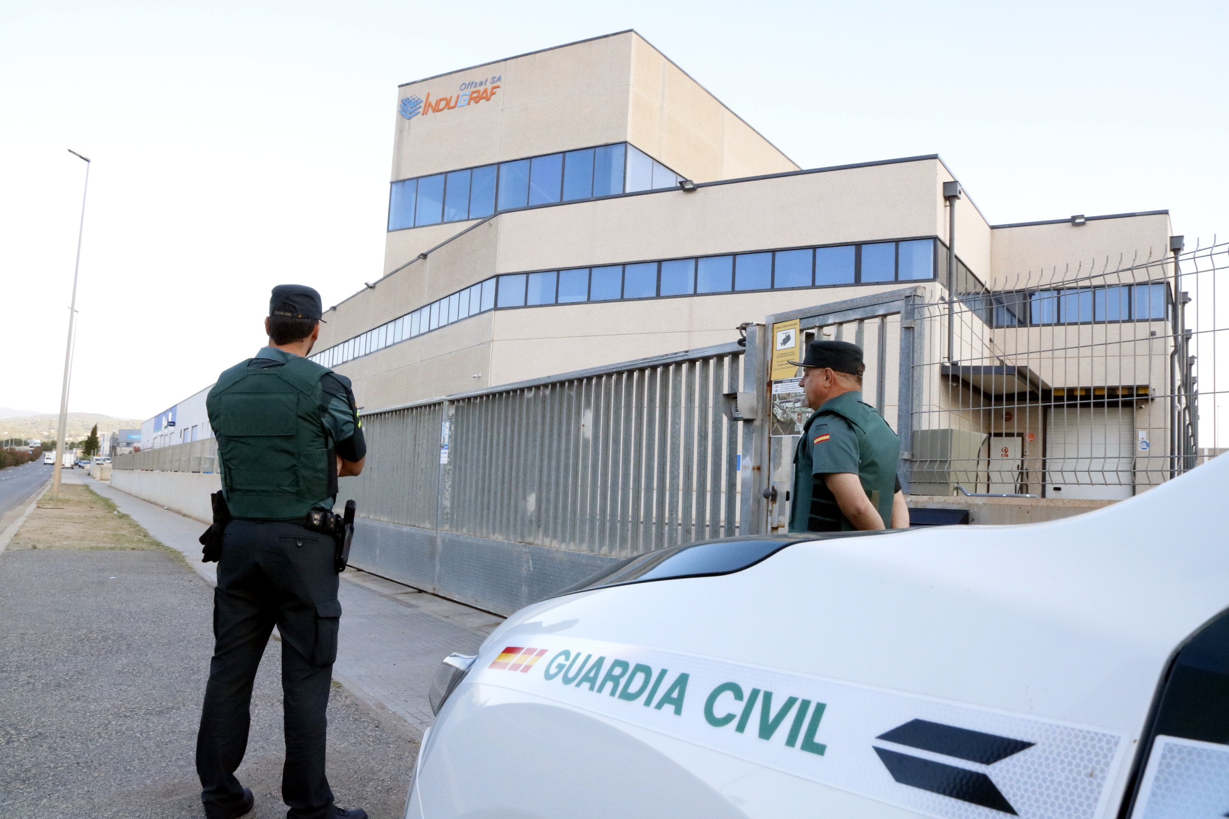 Spanish Guardia Civil officers waiting in front of a print shop (by ACN)