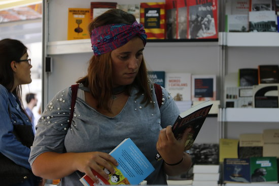 A woman reads a book in the Catalan Book Week Fair in Barcelona (by ACN)