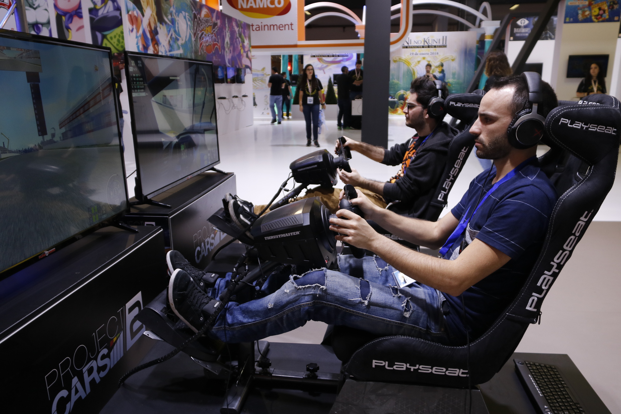 Two people trying out a driving simulation at GamesWorld 2017 (by ACN)