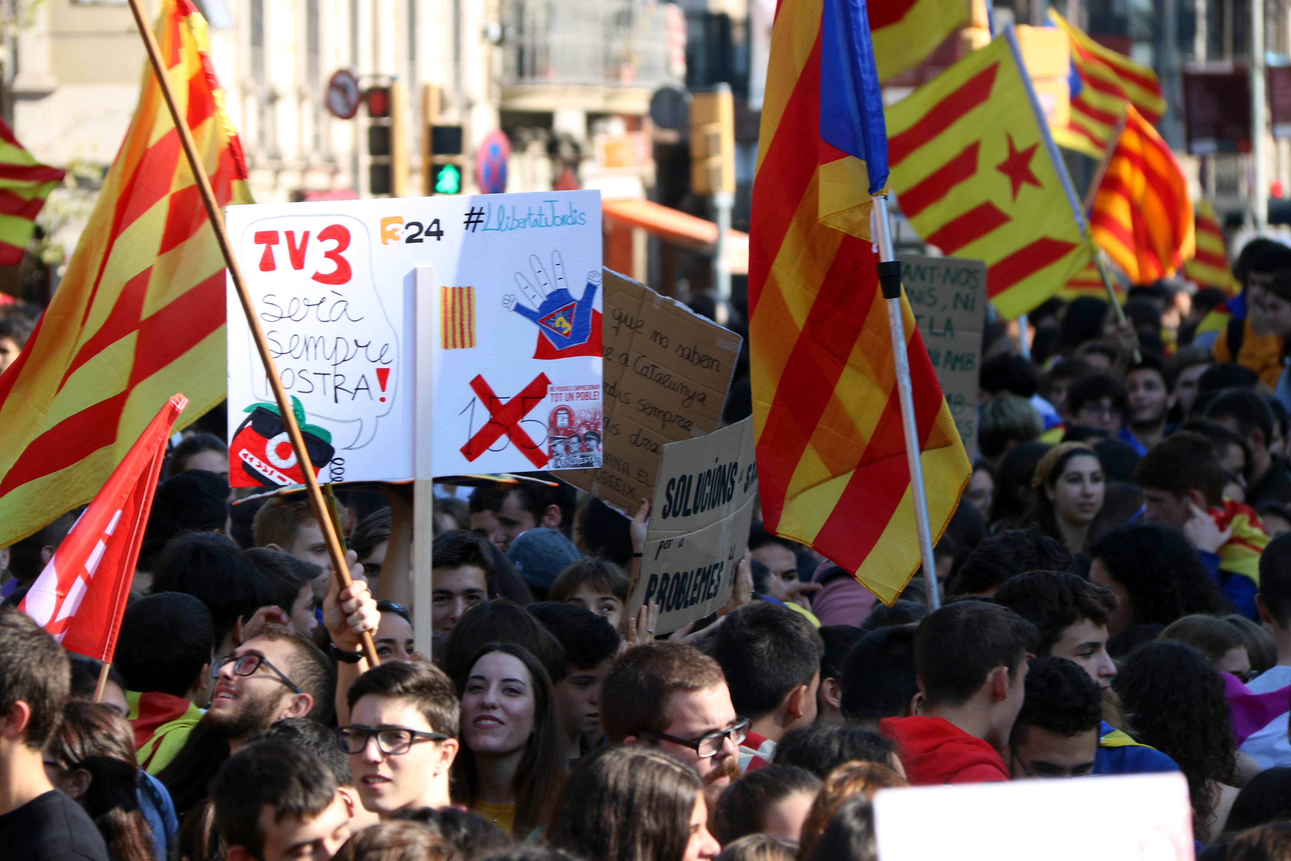 Students march in the center of Barcelona holding a sign defending one of Catalonia's public media outlets, TV3 (by ACN)