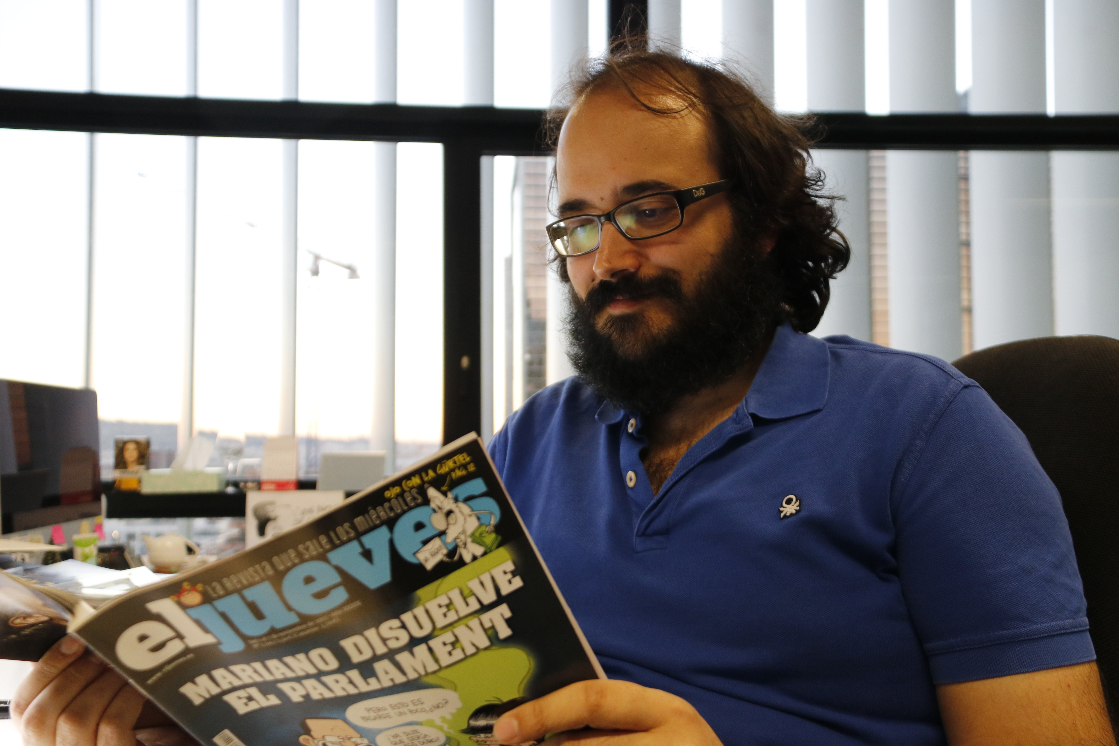 The editor of the satirical magazine 'El Jueves,' Guille Martínez, reading a copy of the publication (by ACN) 