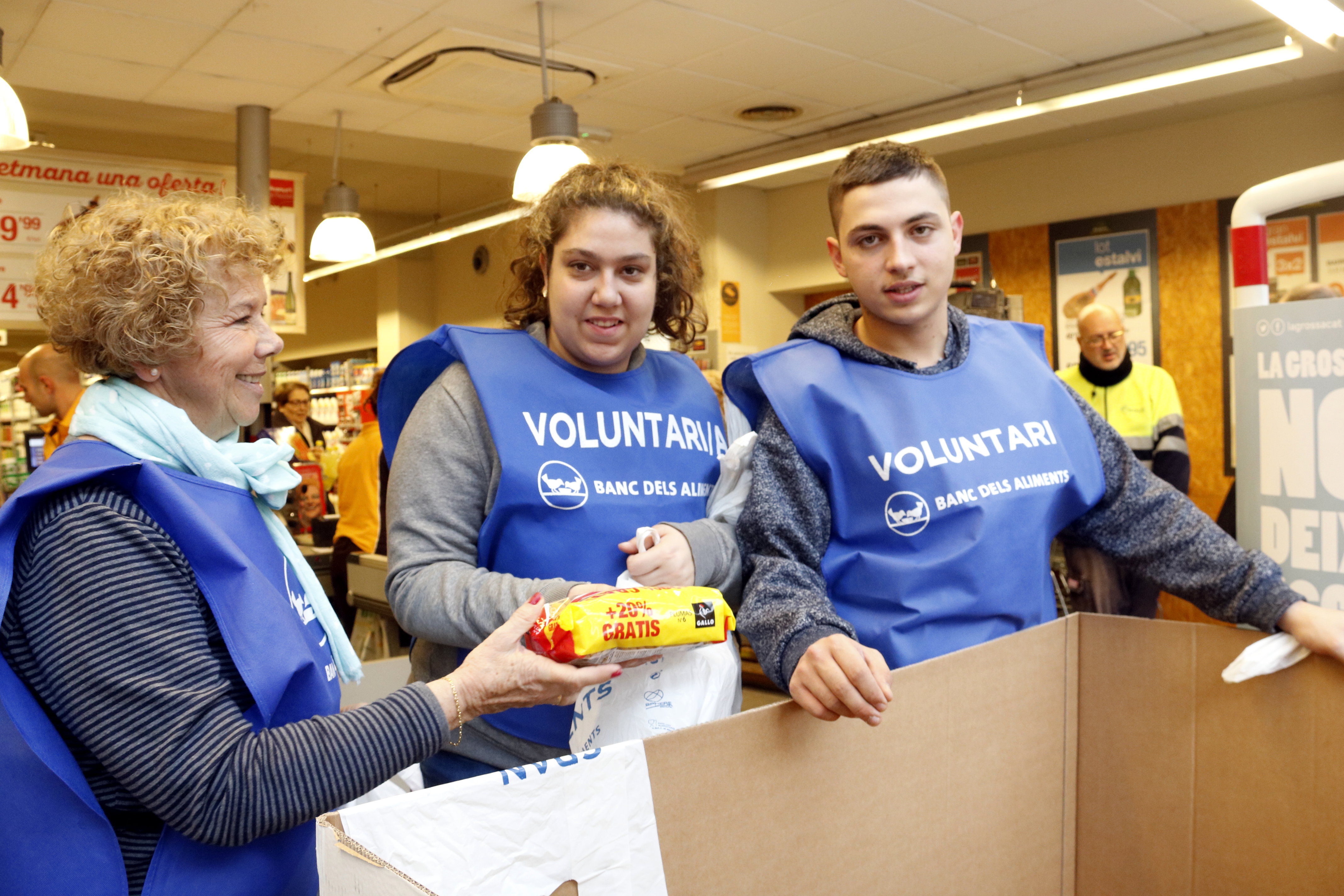 Three volunteers from the food bank for the Gran Recapte at the Marina market supermarket, on December 1 2017 (by Laura Fíguls)