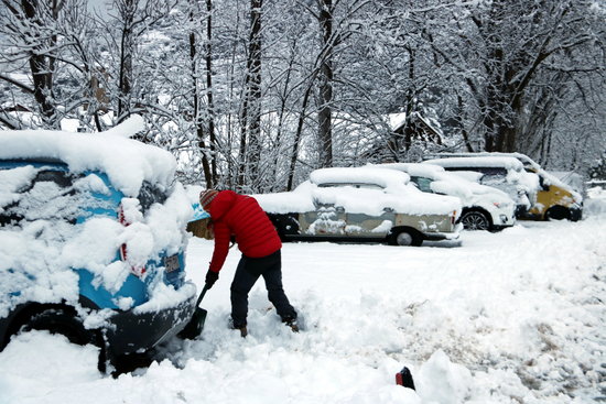 A man removing snow from his car in the Catalan Pyrenees (by Marta Lluvich)