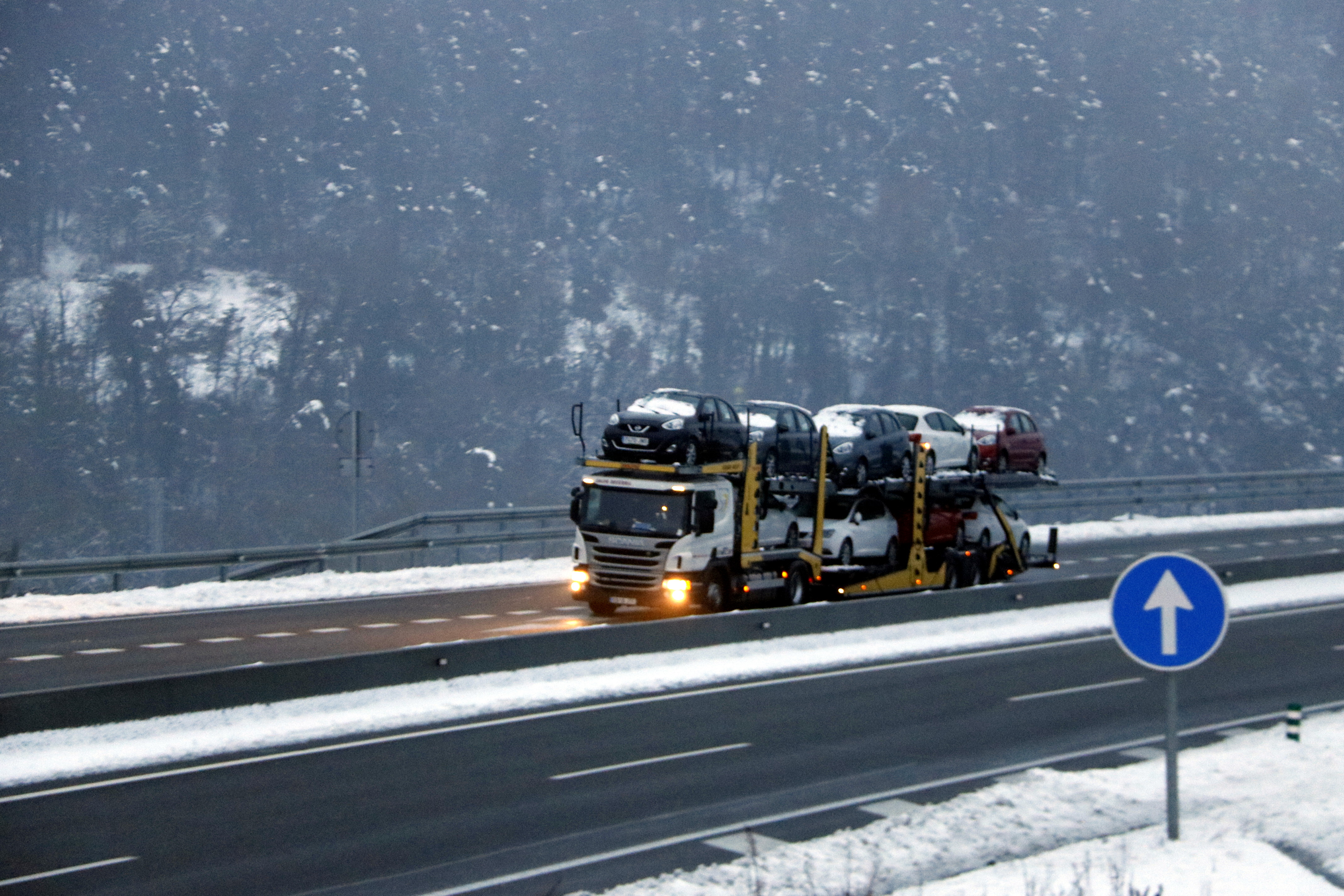 Snow falls while a lorry transports cars on the highway on February 28 2018 (by Laura Busquets)