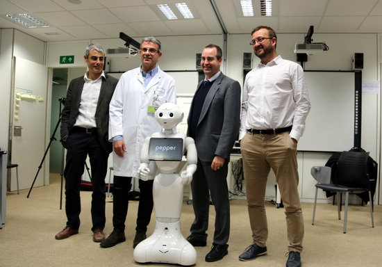 Members of the Althaia Foundation alongside the robot Pepper (by ACN)