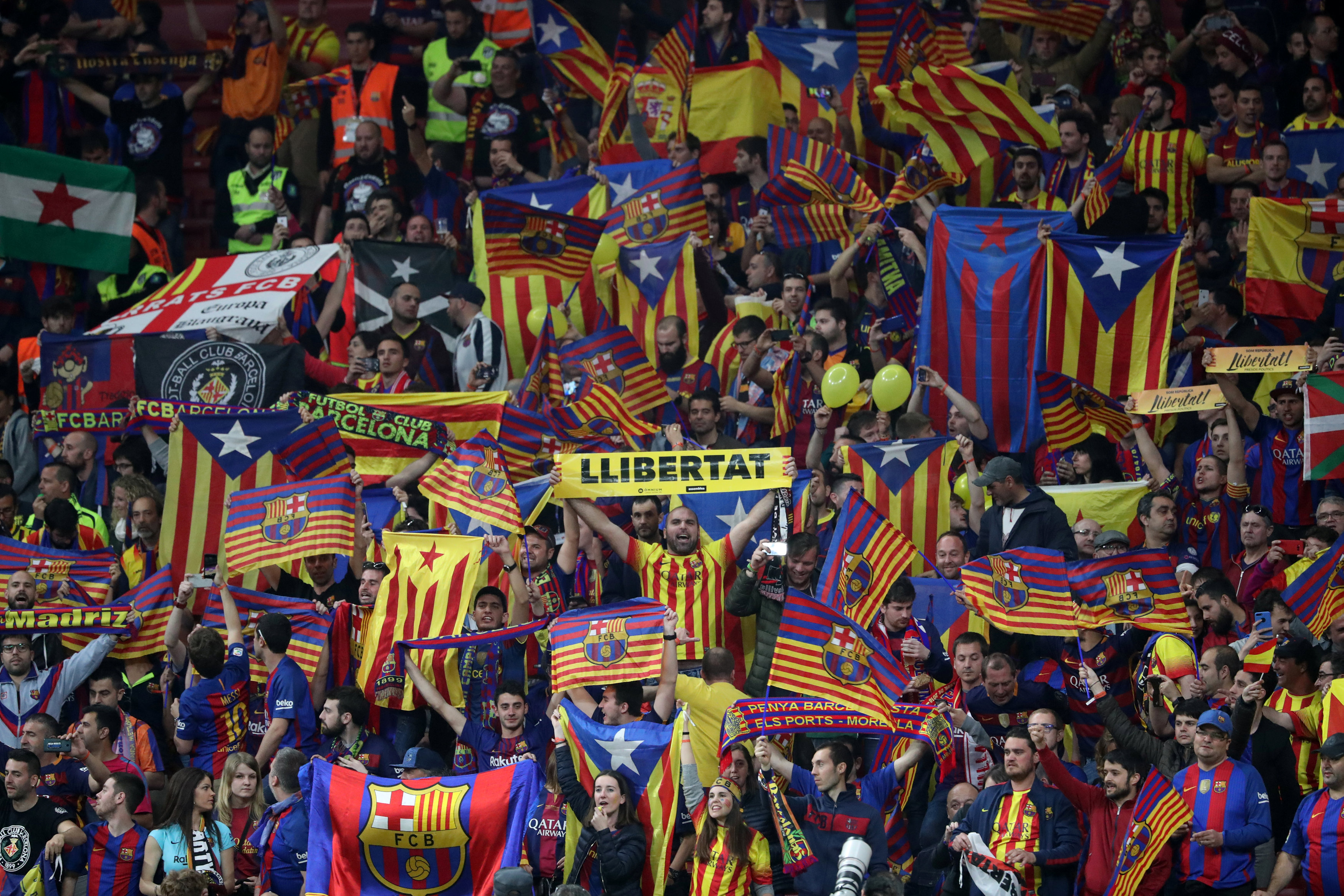 Barcelona fan holds up a “Llibertat” (freedom) banner before the match as Catalan and Catalan independence flags are displayed (courtesy of REUTERS/Susana Vera) 