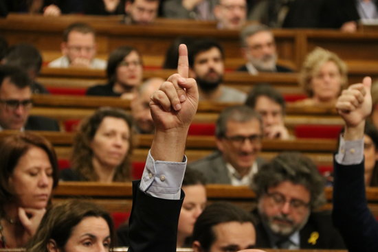 An MP voting in the Catalan parliament (by Pere Francesch)