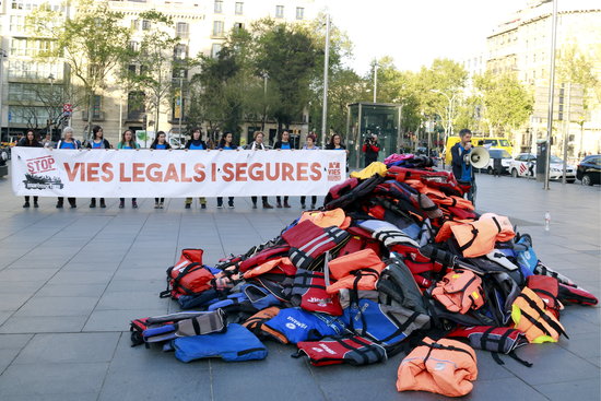Stop Mare Mortum activists in central Barcelona with pile of life jackets (by ACN)