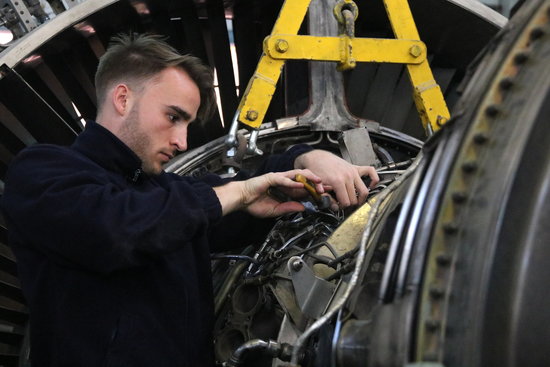 A young man working on a plane engine (by ACN)