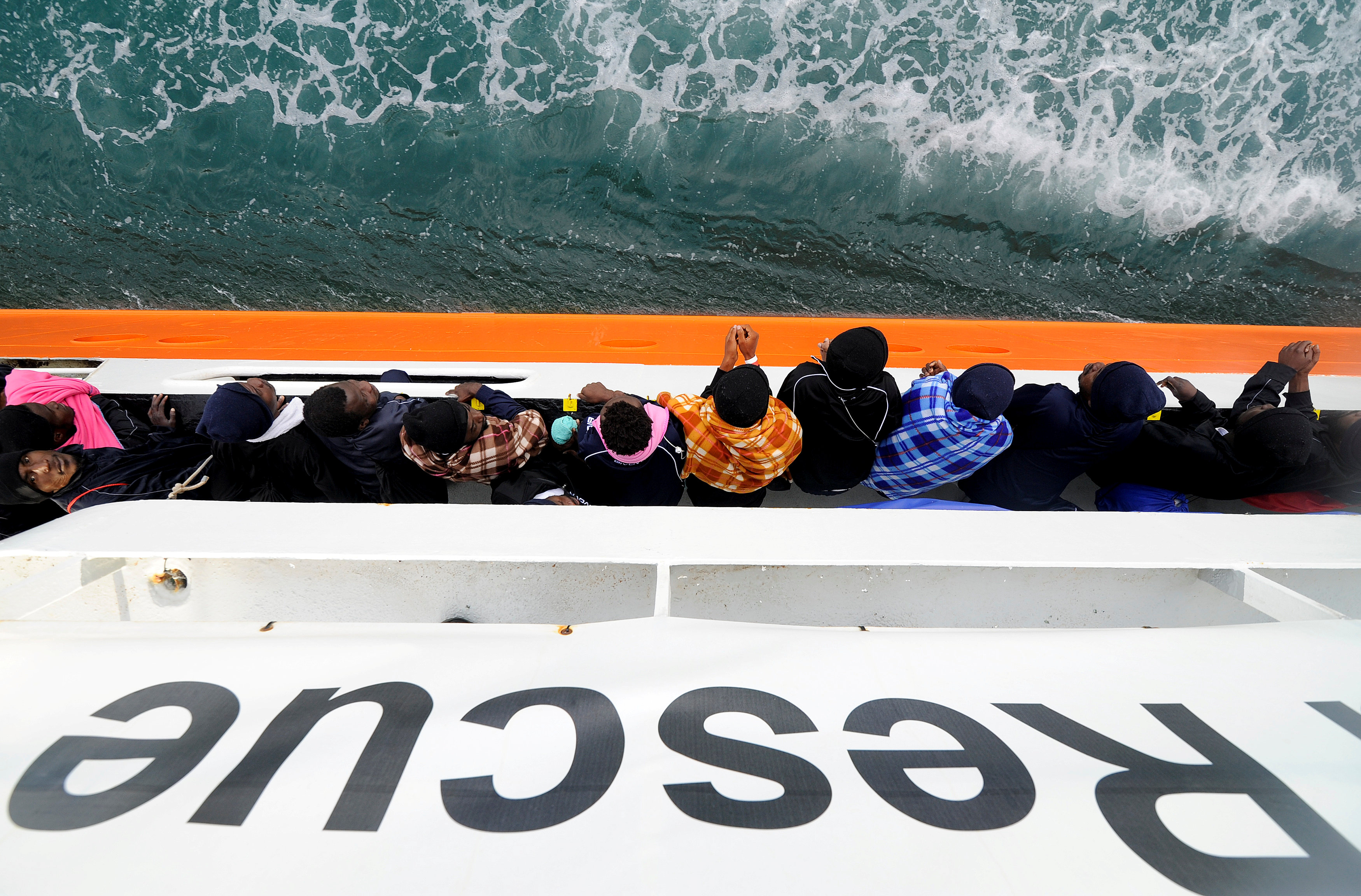 Migrants wait to disembark from Aquarius in the Sicilian harbour of Catania (REUTERS)