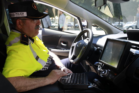 Guardia Urbana officer using computer in new hybrid car (by ACN)