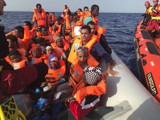 Proactiva Open Arms crew with rescued migrants (Proactiva Open Arms)
