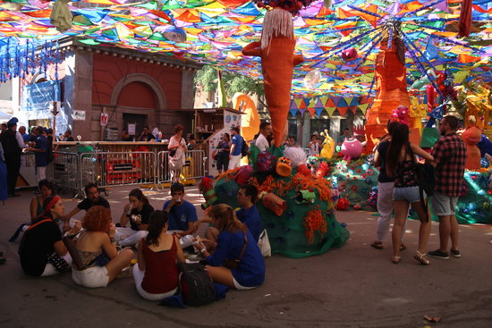 The collective breakfast held in Gràcia on August 15 with a decorated square in the background (by Elisenda Rosanas)