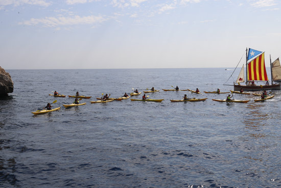 18 yellow kayaks forming a bow to back the incarcerated and exiled officials in the Illes Medes on August 21, 2018 (by Aleix Freixas)