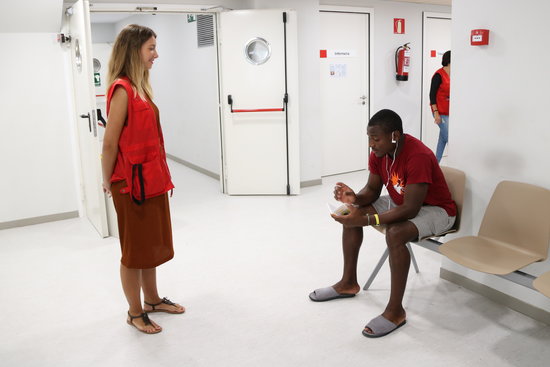 A migrant individual at the CANE welcome center in Barcelona speaks to a member of the Red Cross on August 29 2018 (by Andrea Zamorano) 
