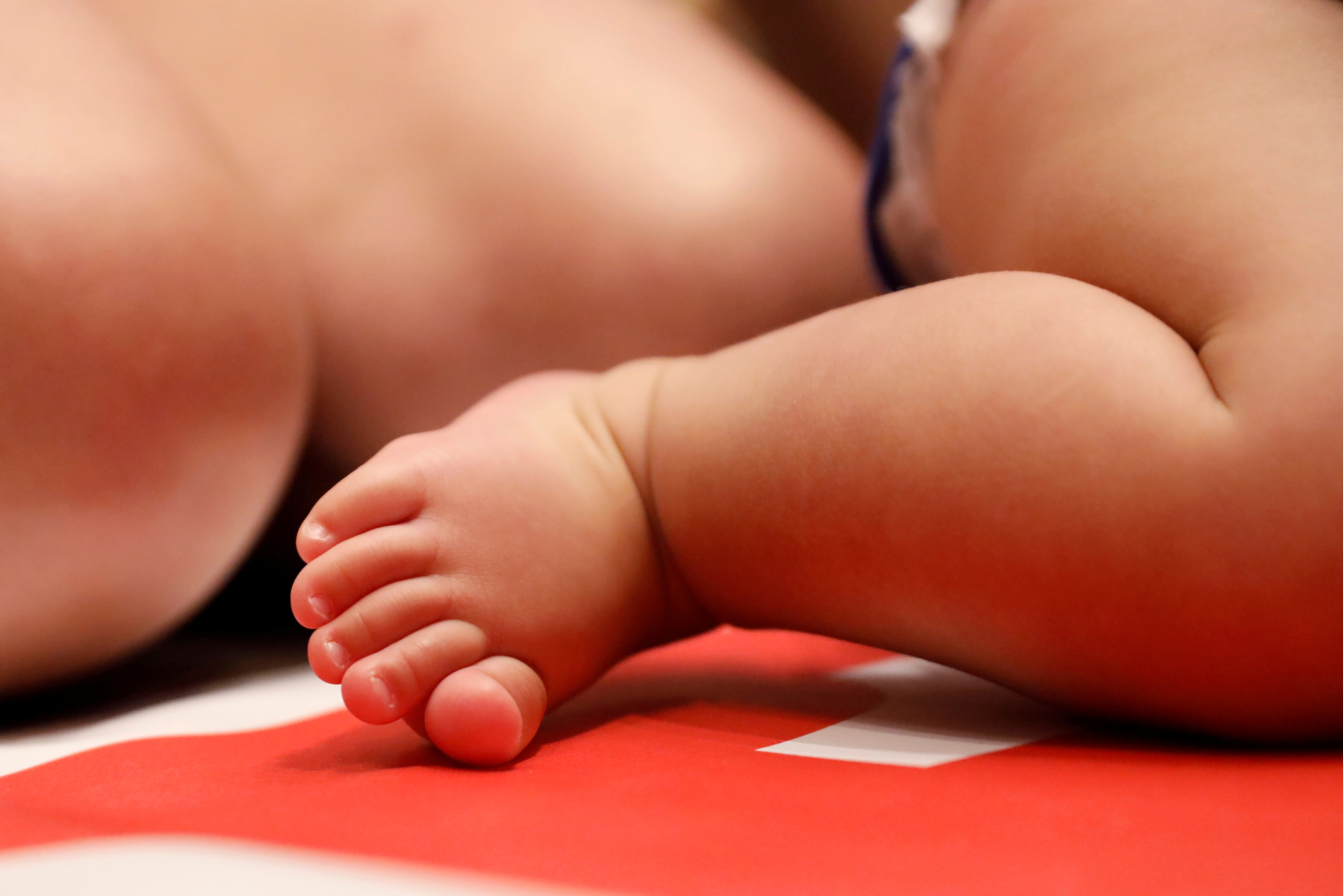 The foot of a baby next to their mum (by Reuters)