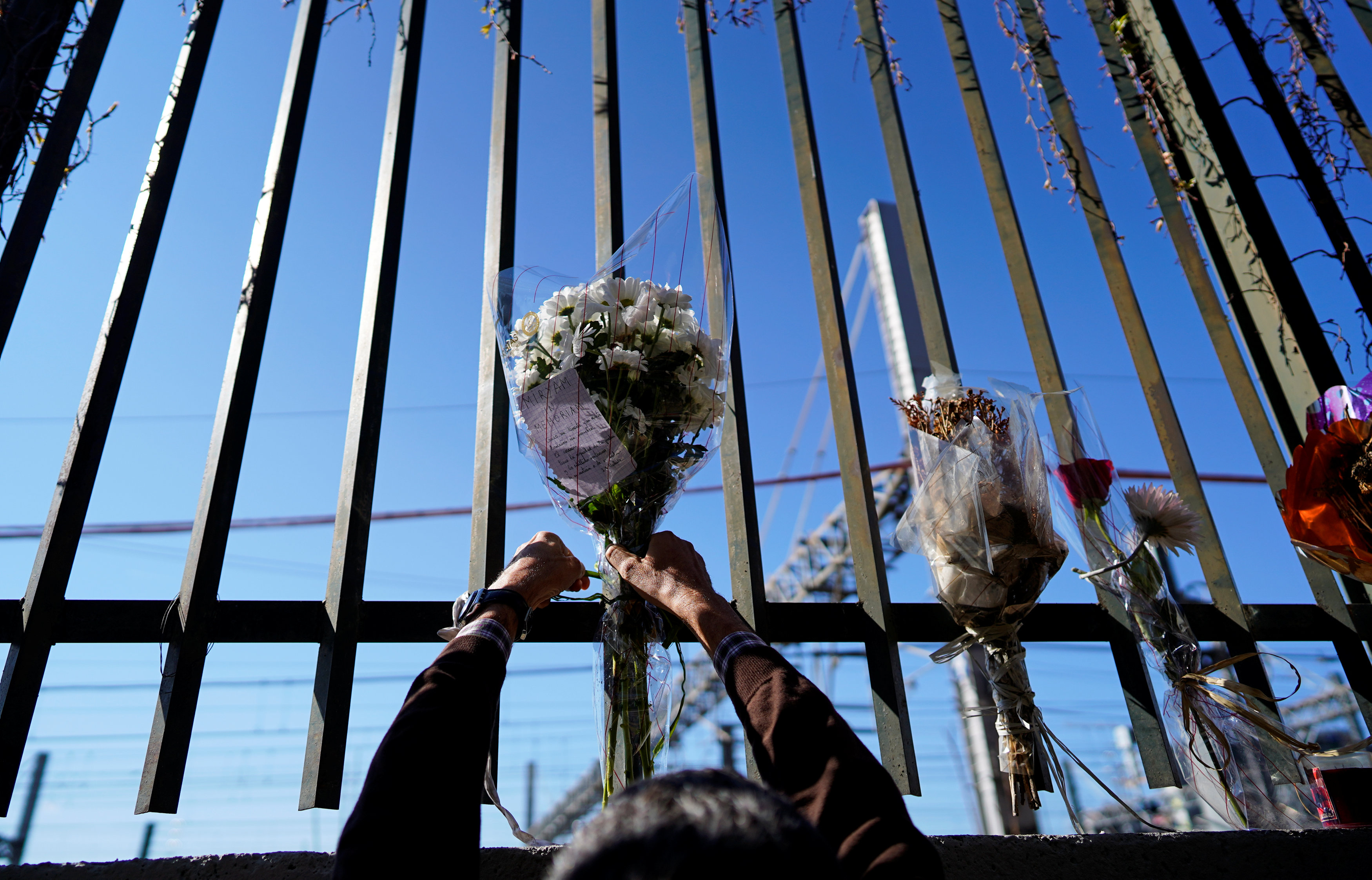 A relative of the Madrid train attacks victim, places flowers outside the Atocha station on the 15th anniversary of the attacks in Madrid (by REUTERS/Juan Medina)