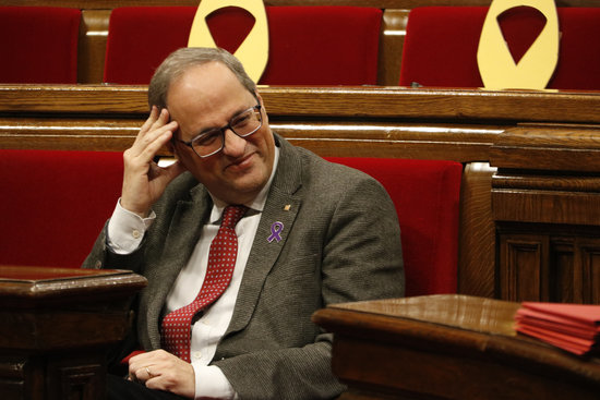 Catalan president Quim Torra sitting next to parliament seats with yellow ribbons in support of jailed and exiled pro-independence leaders (by Bernat Vilaró)