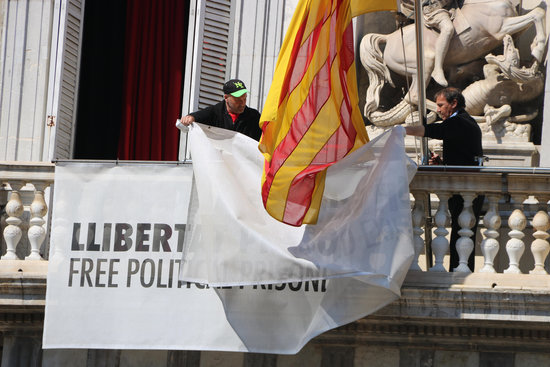 Catalan government workers remove banner from building façade (by ACN)