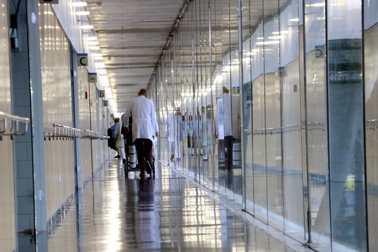 Image of a corridor in Hospital del Mar, with Dr Robert Güerri and a patient on April 3, 2019 (by Laura Fíguls)