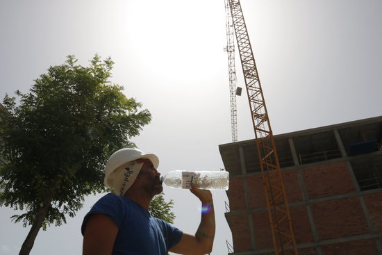 A contruction worker drinks water during the June 2019 heatwave. (Photo: Laura Cortés)