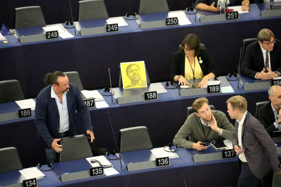 Oriol Junqueras's photo sits atop an empty seat in the European parliament beside ERC party colleague Diana Riba. (Photo: Blanca Blay)