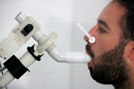 A patient breathes into medical equipment during an asthma examination in Vall d'Hebron hospital. (Photo: Miquel Codolar)