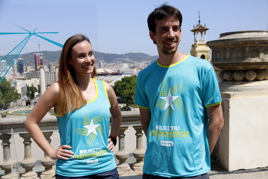 Image of two young people showing the official T-Shirts of the 2019 National Day pro-independence demonstration, on June 26, 2019 (by Guillem Roset)