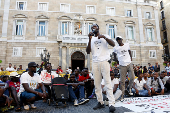 A member of the street sellers speaks to the gathered protesters at the demonstration for the street sellers' rights in Barcelona. (Photo: Laura Fíguls)