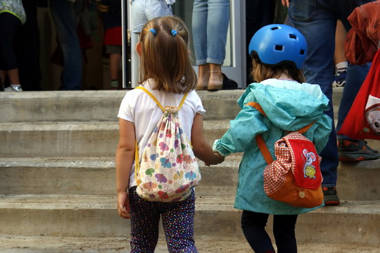 Two children holding hands on their way to school on September 12, 2019 (by Elisenda Rosanas)