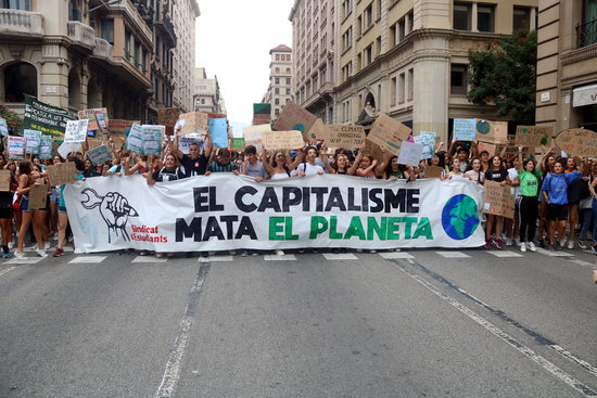 Image of a demonstration for climate with a banner reading 'Capitalism kills the planet,' on September 27, 2019 (by Gerard Comas)
