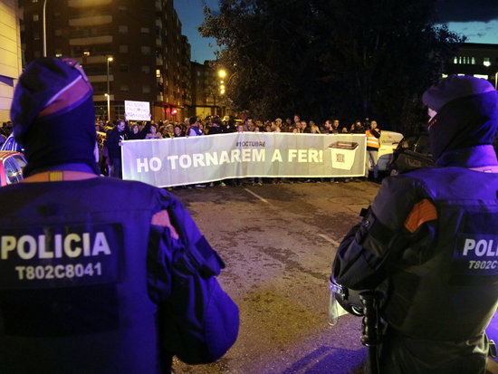 Two Catalan police officers in front of pro-independence protesters in Lleida (by Anna Berga)